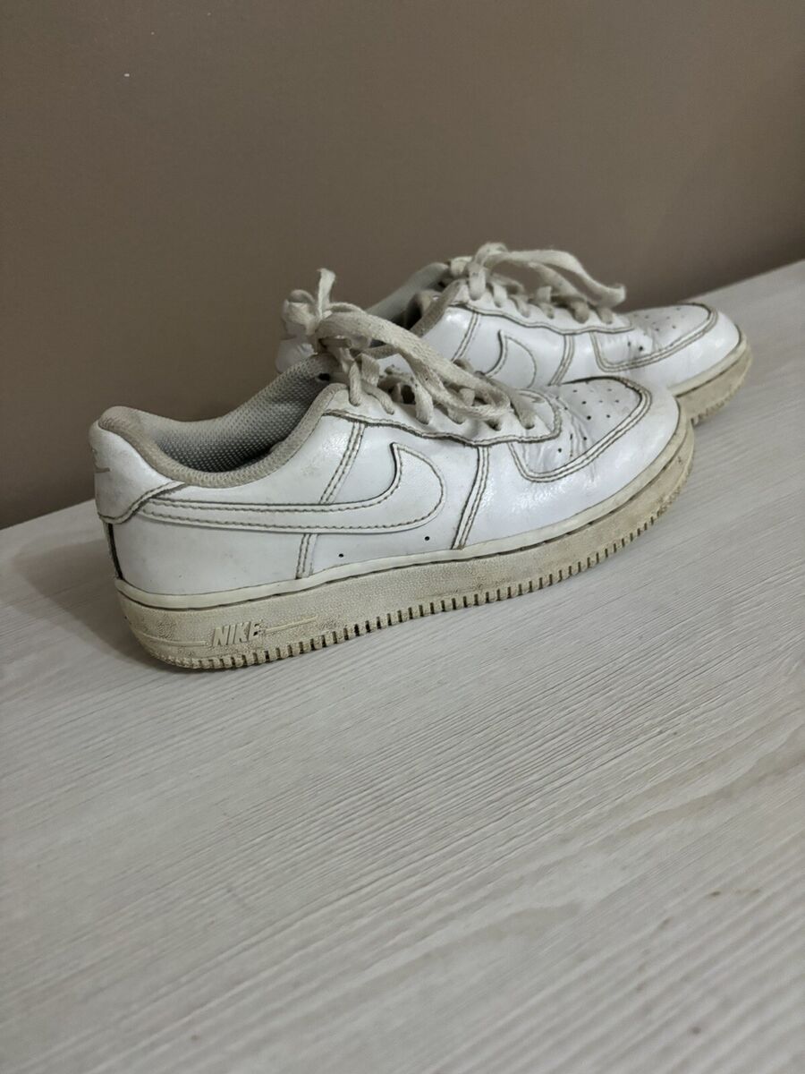 White low-top sneakers on wooden surface representing Averon unisex footwear collection.